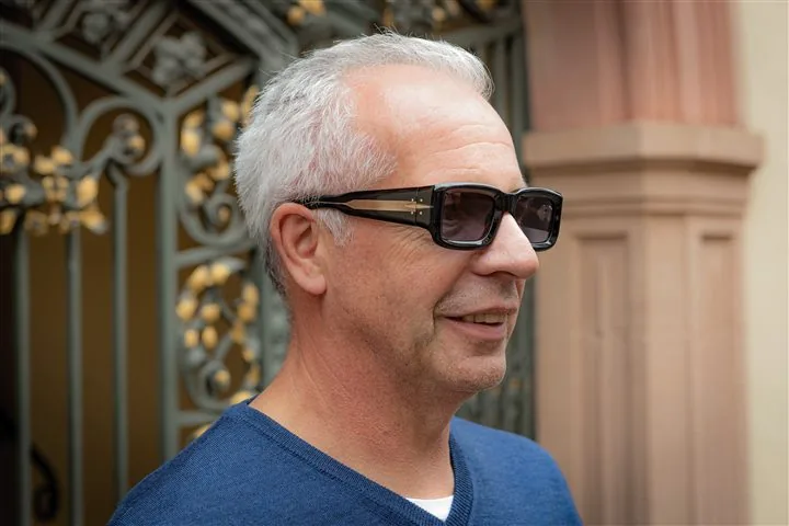 Kunde mit Sonnenbrille vor historischem Freiburger Tor